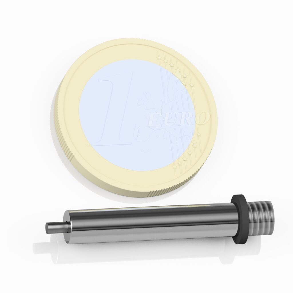 A mini cylinder lies next to a 1 euro coin to show how small the cylinder really is. The cylinder is only slightly longer than the coin.